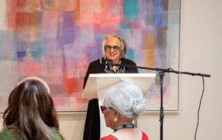 Artist speaking at the podium during the Lonsdale Gallery’s Artists in the Spotlight series.