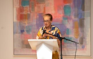 Guest speaker at the podium during Baycrest’s Artists in the Spotlight gallery talk.