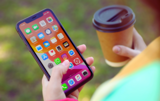 A person holding an iphone with different apps to help manage caregiving