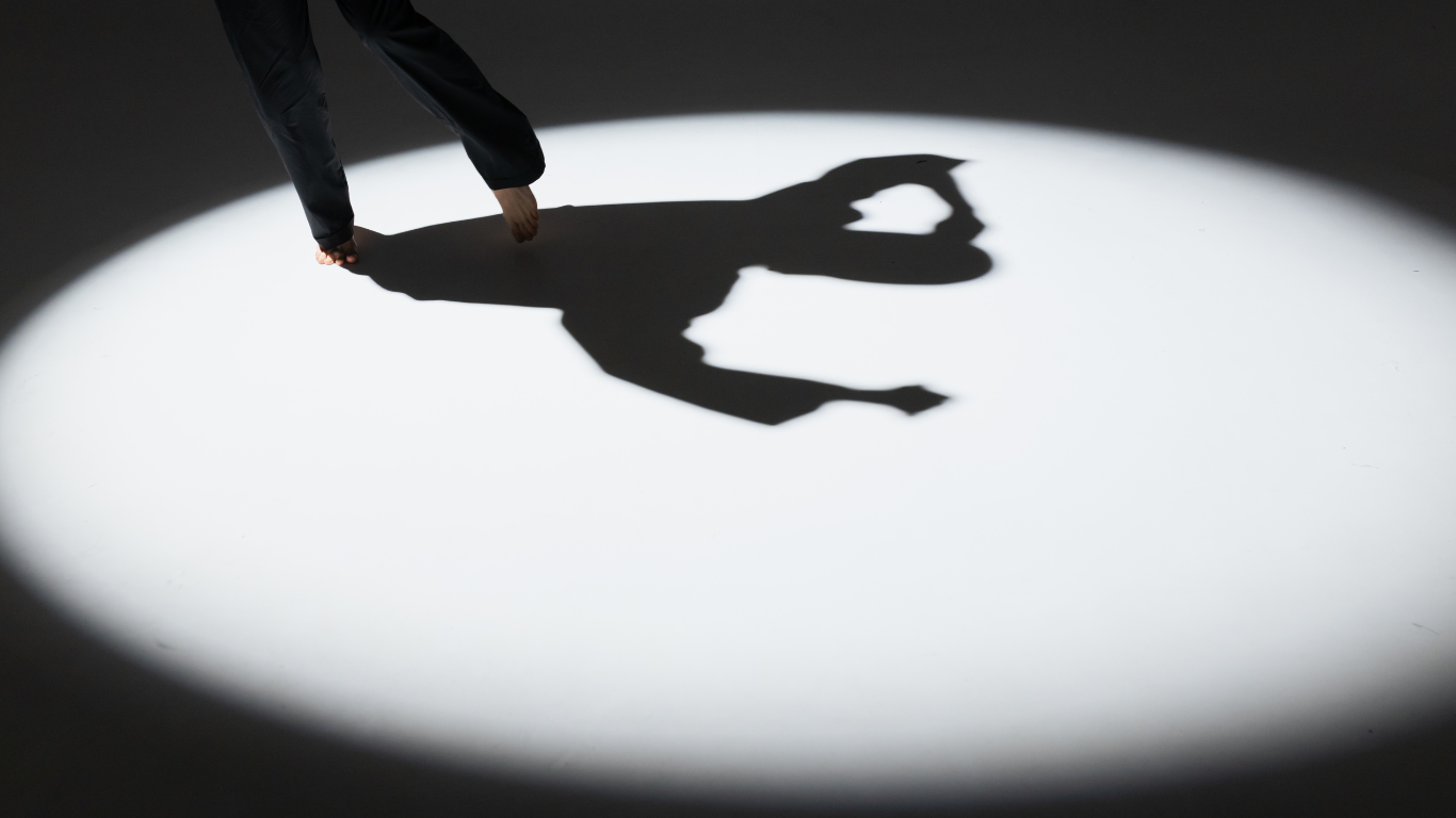 A shadow of a dancer pointing their toe