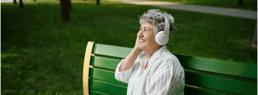 Elderly woman smiling while listening to music, showing the link between music and cognitive function